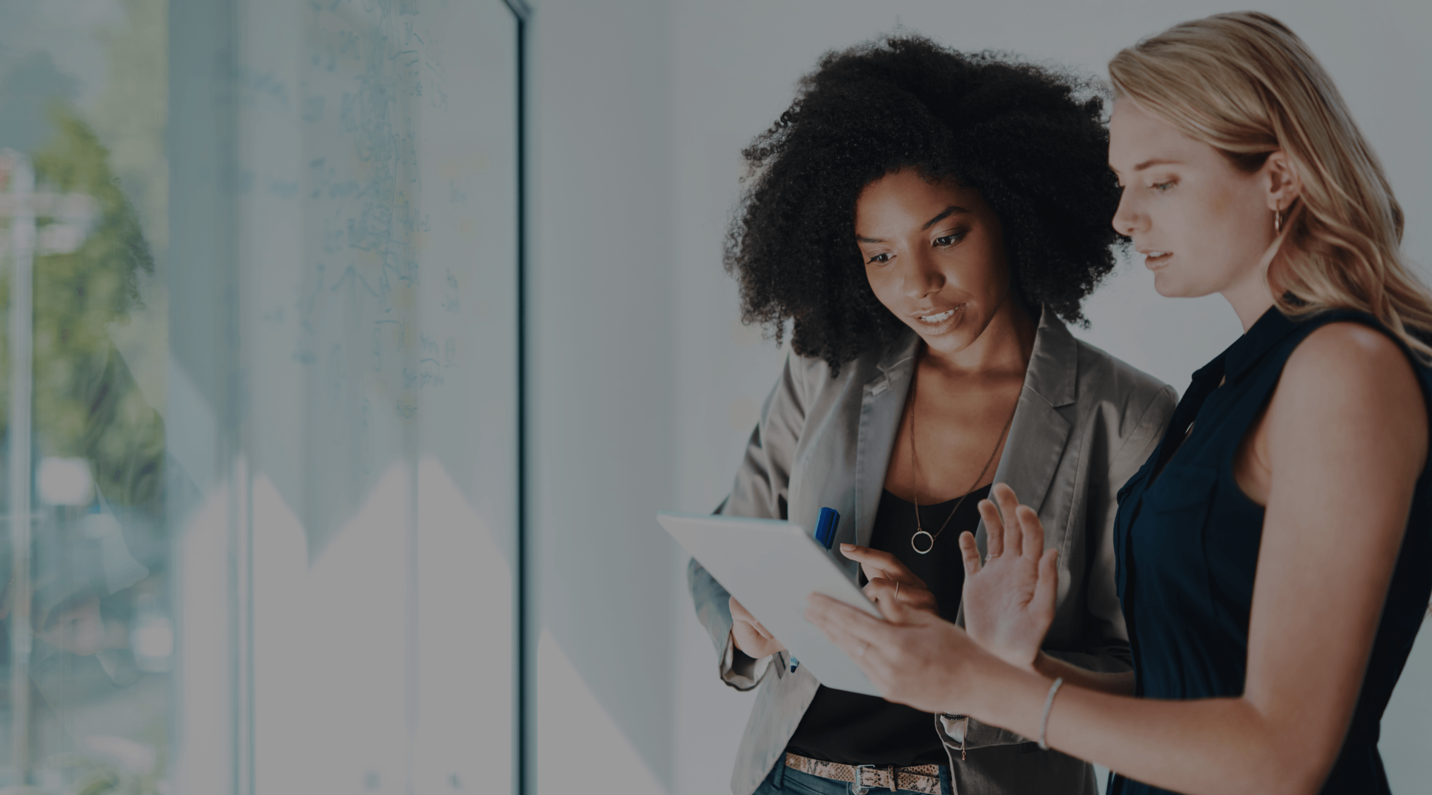 Image of two women looking at a tablet.