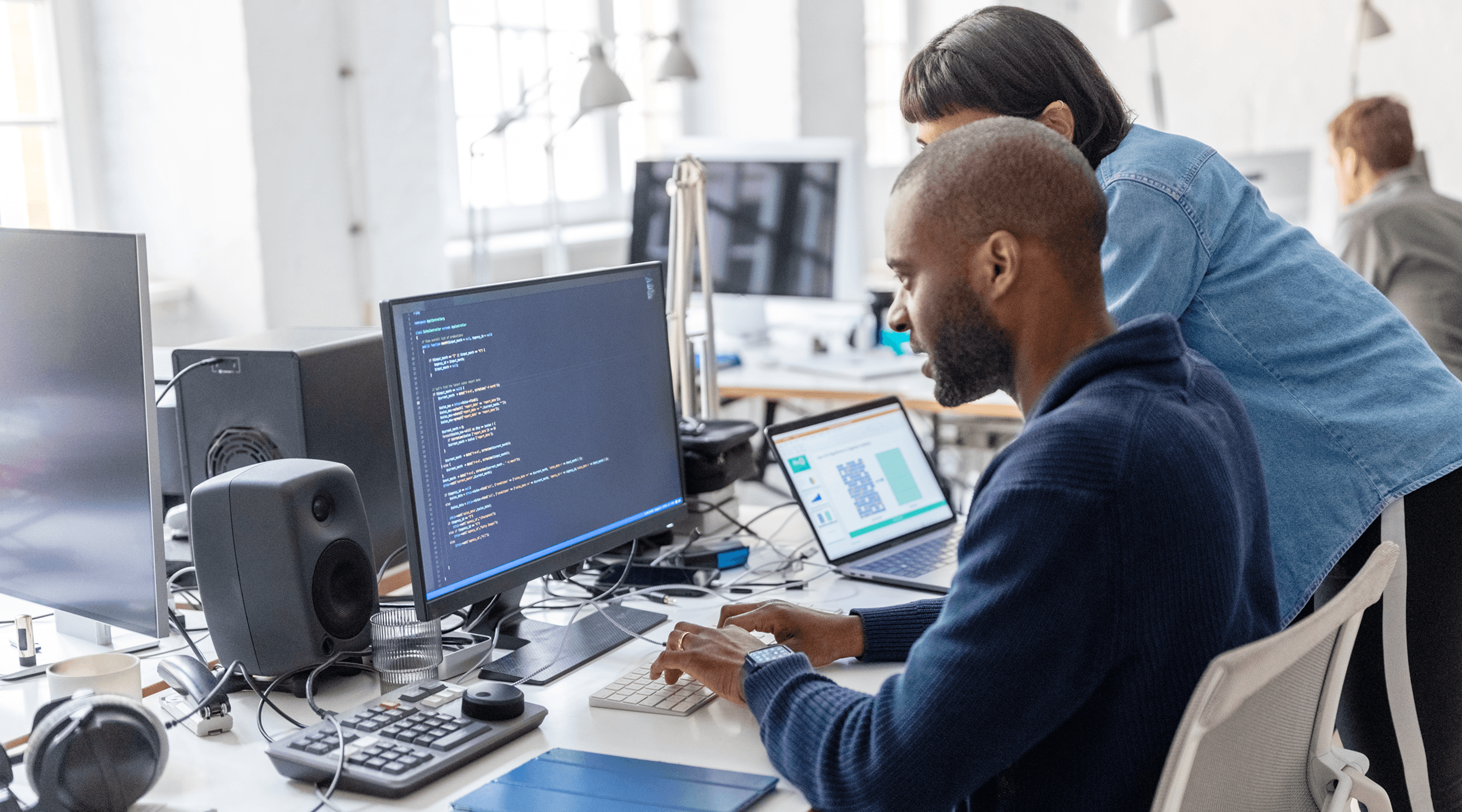 A man and a woman are looking at a computer screen.