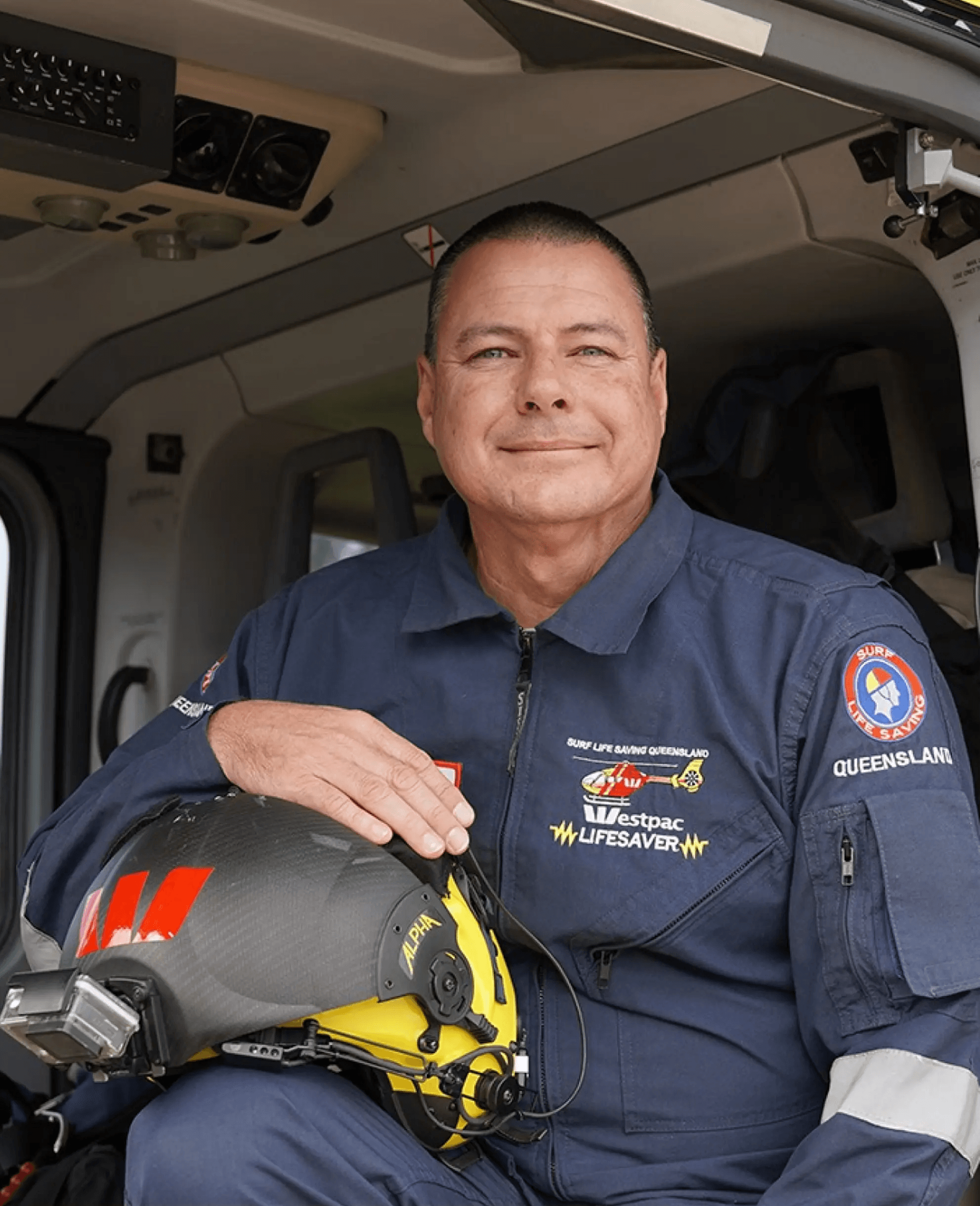 Image of a pilot sitting in an aircraft holding this helmet.