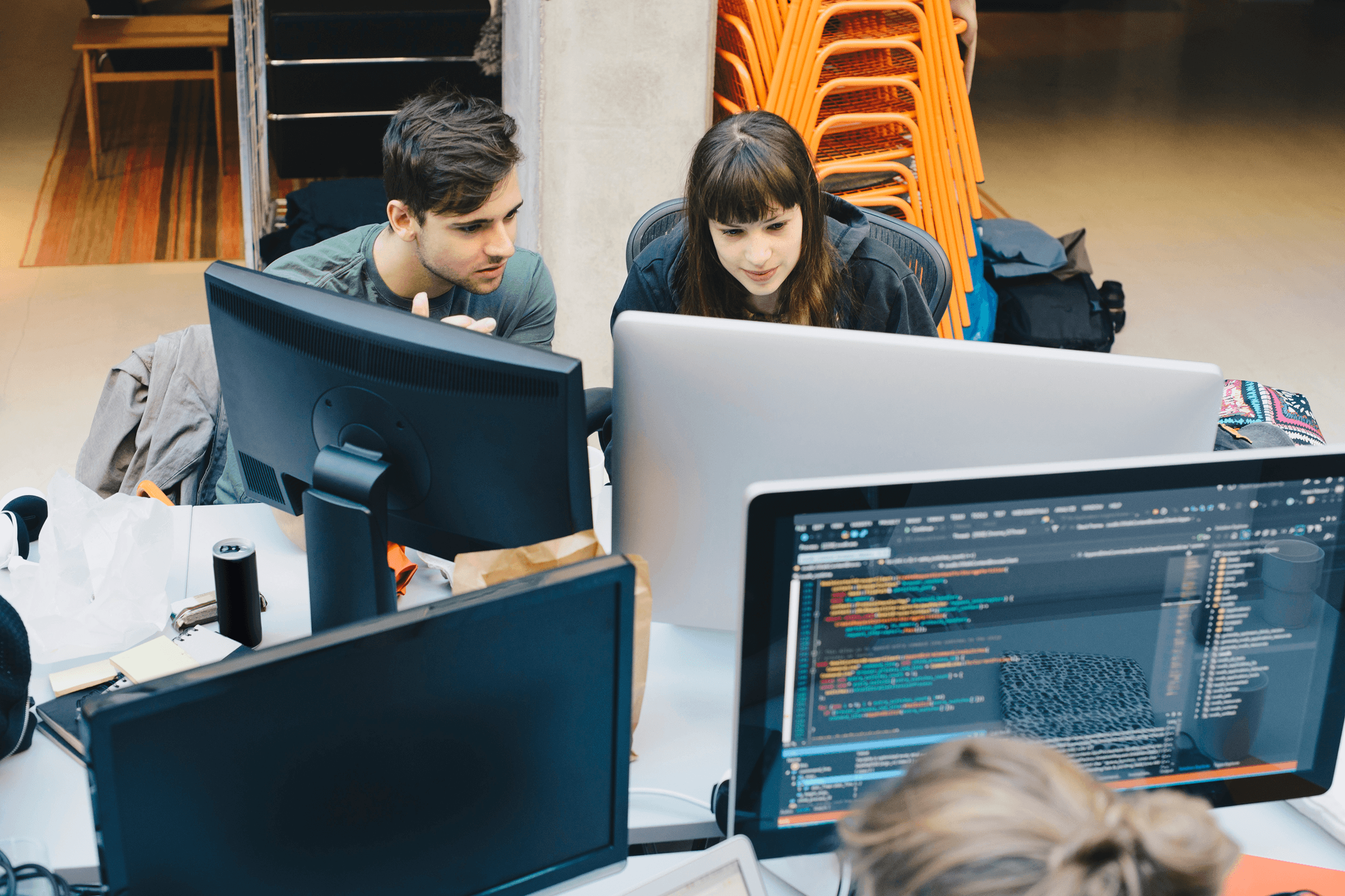 Man and women collaborating on computers in an office.